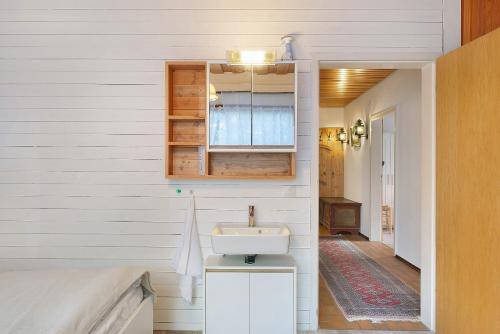 a white bathroom with a sink and a mirror at Deluxe Apartment Ferienwohnung in Wieden