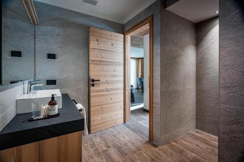 a bathroom with a sink and a shower at Arnica Alpin Lodge 1 in Cavedago