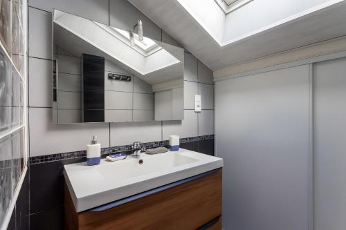 a bathroom with a white sink and a skylight at Maison Xara-heguia in Hasparren