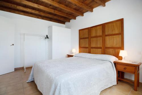 a bedroom with a large bed with a wooden headboard at San Roque 2 in Tinajo