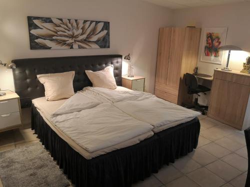 a large bed in a bedroom with a desk at Roca Penthouse in Estepona