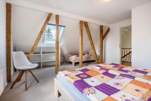a bedroom with a bed and a chair at Ferienhaus Hedrich in Gülzow