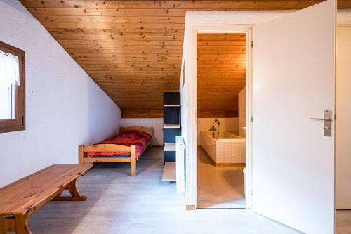 a room with a bed and a bench in a room at L'esterelle in La Plagne Tarentaise
