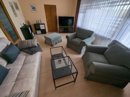 a living room with a couch and chairs and a table at Ferienwohnung Buedinger Weg in Gründau