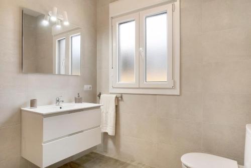 a white bathroom with a sink and a mirror at Villa Montenmedio - Paula in El Soto
