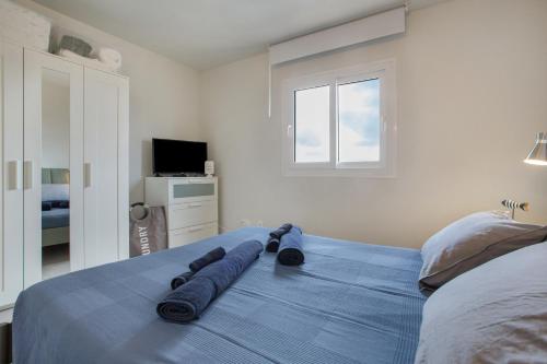 a bedroom with a blue bed with a window at Morada Ribes in Costa de Antigua