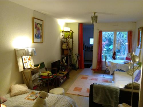 un salon avec un lit et une fenêtre dans l'établissement Joli studio avec jardinet, à Avignon