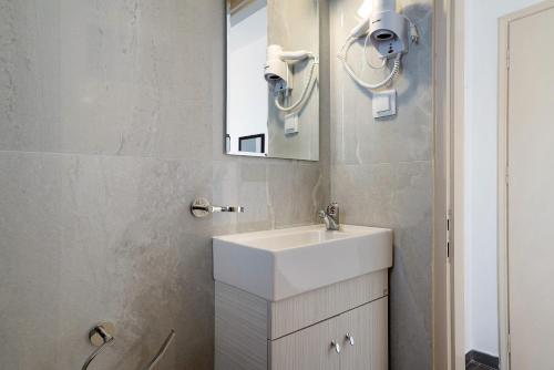 un bagno con lavandino bianco e specchio di Iguana studio 3 a Preveza