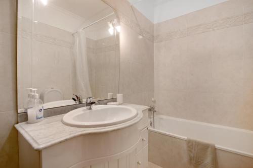 a white bathroom with a sink and a bath tub at Glamorous Villa T3 Praia Verde in Castro Marim