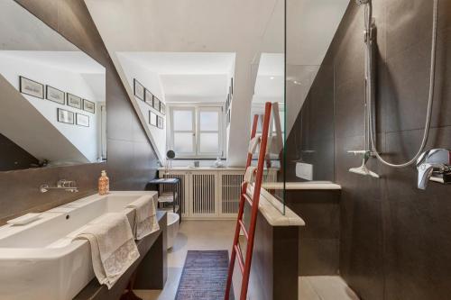 a bathroom with a bath tub and a sink and a ladder at Attico Palazzo Giustiniani in Genoa