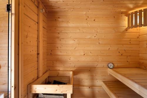 an inside of a wooden sauna with a clock at Haus Möwe und Robbe in Dagebüll