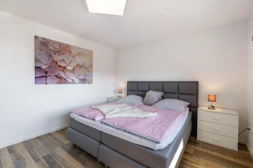 a bedroom with a bed and a painting on the wall at Ferienwohnung Frank in Melschede