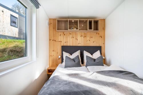 a bedroom with a bed and a window at Side-by-Side Tiny Houses in Untergriesbach
