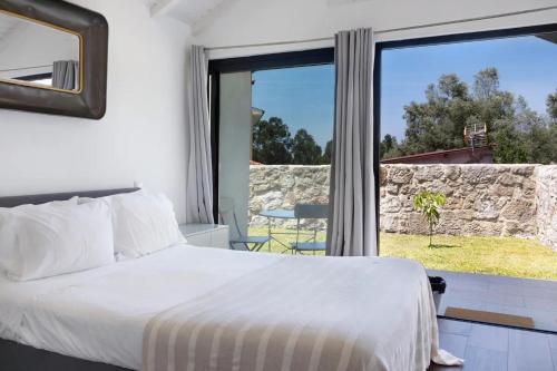 a bedroom with a bed and a large window at Casa do Mestre Studio e Suíte Extra in Vila de Punhe
