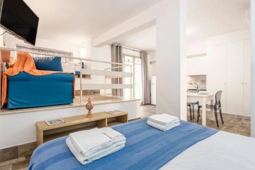a bedroom with a blue bed and a desk and a kitchen at Casavacanzefranca - 15 in Terrasini