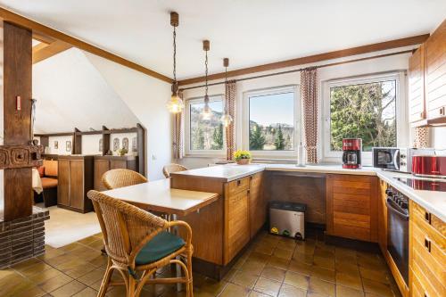 a kitchen with wooden cabinets and a table and chairs at Ferienwohnung Grothoff in Olsberg