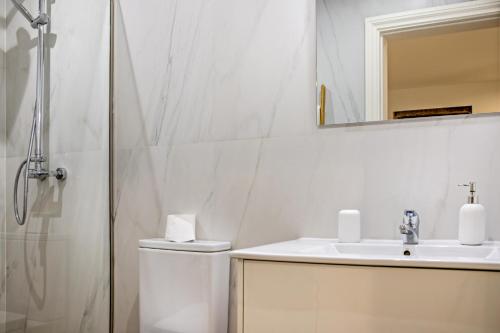 a bathroom with a toilet and a sink and a shower at Casa do Mestre Studio e Suíte Extra in Vila de Punhe