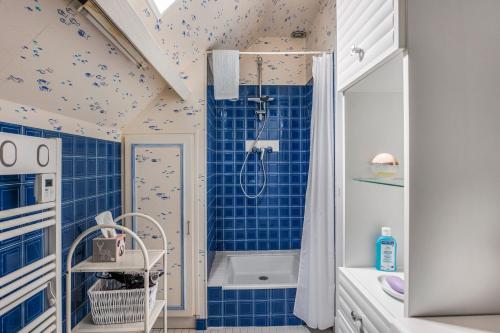 a bathroom with a shower and blue tiles at Chambre d'hôtes - Mon Plaisir in Civray-de-Touraine