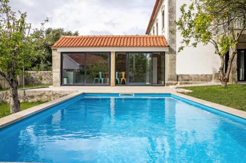 a swimming pool in front of a house at Casa do Mestre Studio e Suíte Extra in Vila de Punhe