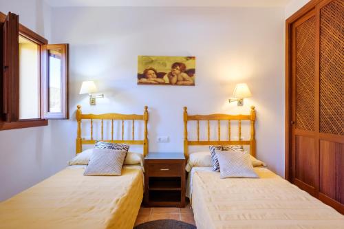 a bedroom with two beds and a window at Can Ramon 1 in Sant Josep de sa Talaia