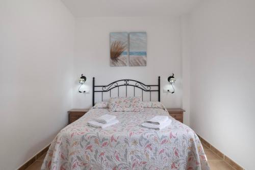 a bedroom with a bed with two lamps on it at Casa Nesenka 1 in Zahora
