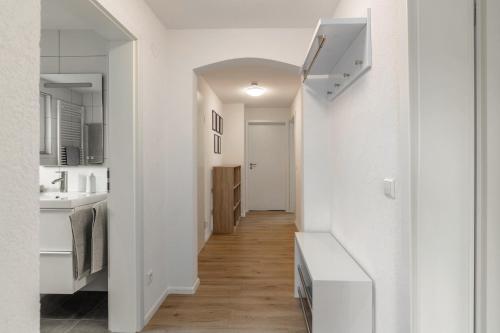 a hallway leading to a kitchen with white walls and wood floors at Ferienwohnung K5 in Wehr