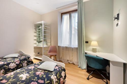 a bedroom with two beds and a desk and a window at Soleluna in Vado Ligure