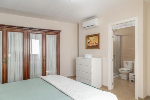 a white bedroom with a bed and a toilet at Ático San Miguel vacacional in Gáldar