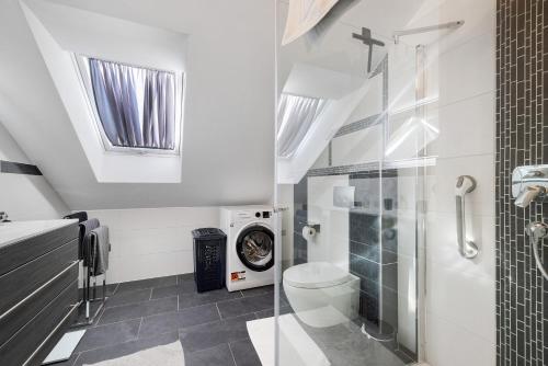 a bathroom with a toilet and a washing machine at Bergliebe in Bitz