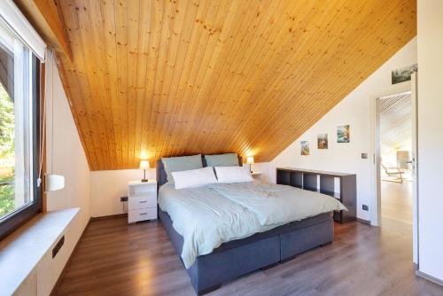 a bedroom with a bed with a wooden ceiling at Bergliebe in Bitz