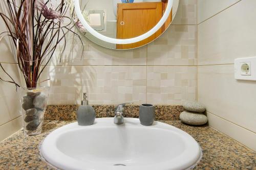a bathroom with a white sink and a mirror at Balcón de Amadores - Beach view in Puerto Rico de Gran Canaria