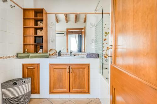 a kitchen with wooden cabinets and a sink at Casa Agnès in Mahón