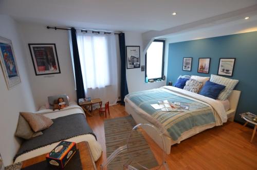 a bedroom with a large bed and a couch at La Musicale in Rouen