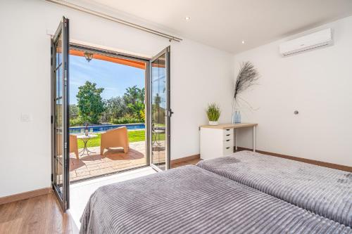 a bedroom with a bed and a sliding glass door at Quinta Dos 4 Ventos in Silves