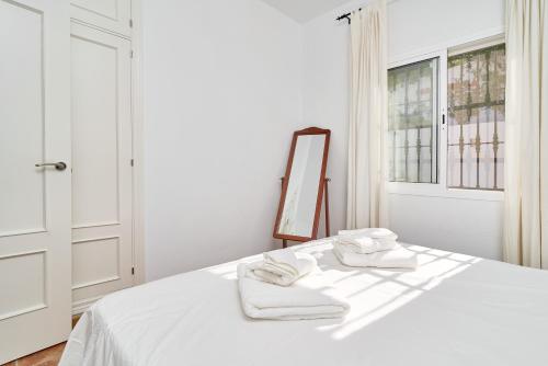 a white bedroom with a bed with towels on it at Villa Amapola in Caserío Carraspite