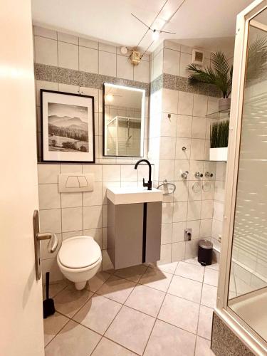 a bathroom with a toilet and a sink and a shower at Apartment Kokorey in Halstenbek