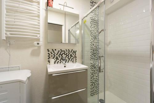 un bagno bianco con lavandino e doccia di Charmant studio 2 a Courchevel
