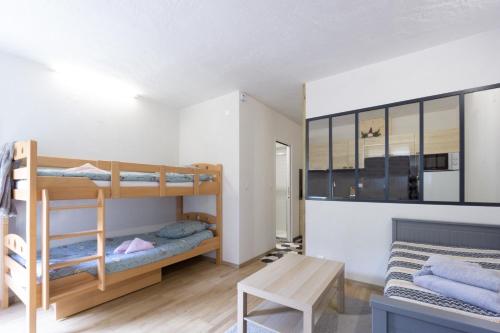 una stanza con due letti a castello e un tavolo di Charmant studio 2 a Courchevel