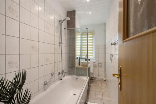 a white bathroom with a tub and a sink at Ferienwohnung San Marino 3 in Mücheln