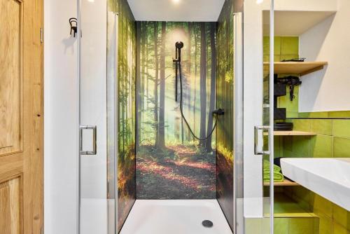 a bathroom with a shower with a forest mural at Haus Auergang Schmallenberg in Schmallenberg