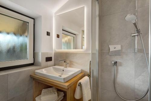 a bathroom with a sink and a shower at Premium App Hofer Silena in Villabassa