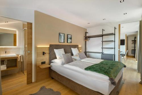 a bedroom with a large bed and a bathroom at Premium App Hofer Silena in Villabassa