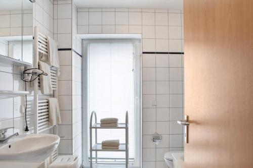 a white bathroom with a sink and a toilet at Ferienwohnung Tannenblick 2-4 in Oberhof