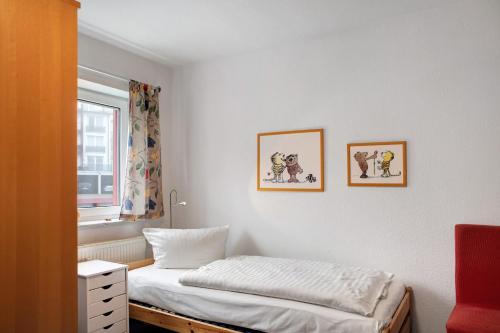 a bedroom with a bed and two pictures on the wall at Ferienwohnung Tannenblick 2-4 in Oberhof