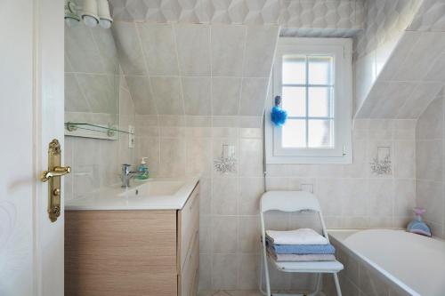 a white bathroom with a tub and a sink and a bath tubermott at Chambre d'hote Reine in Cancale