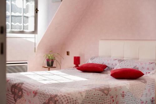 a bedroom with a bed with two red pillows on it at Chambre d'hote Reine in Cancale