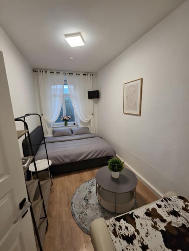 a small bedroom with a bed and a table at Max Hinterhaus in Dresden
