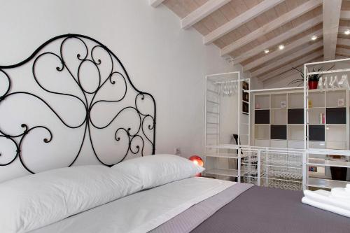 a bedroom with a white bed with a black headboard at Residenza La Fonte Dependance in Laveno-Mombello