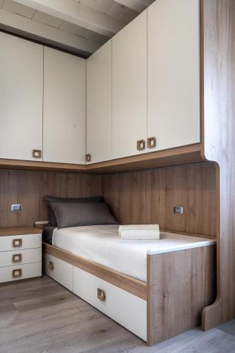 a bed in a small room with white cabinets at Villa Sirmione Front Lake in Sirmione