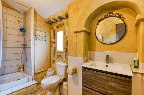 a bathroom with a toilet and a sink and a mirror at Villa - Oasis centre charme in Montpellier